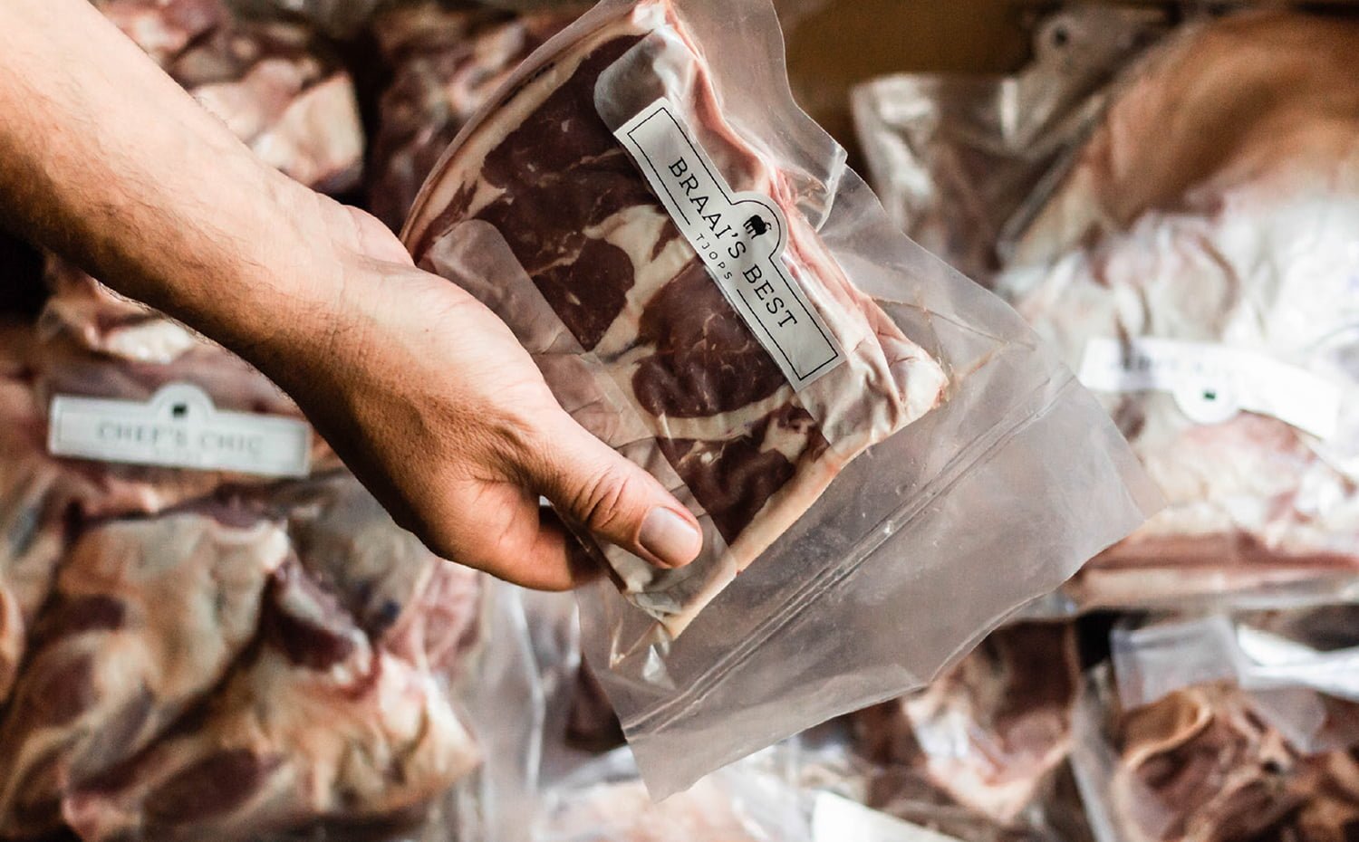 hand unpacking meat from Helderzicht Farm